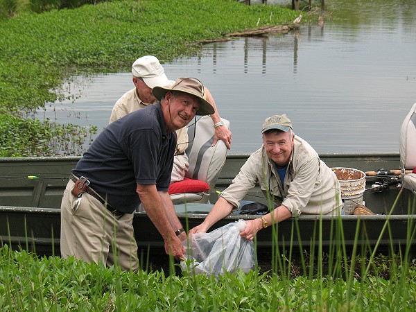 Manager Wilson and Steve Cox dumping golden shiner fry into a Club lake